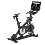 A person cycling on the Bike Commercial S22i NordicTrack Studio Cycle, engaging with the rotating 22-inch touchscreen