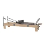 BASI Systems Compact Pilates Reformer showing the beech wood frame and padded carriage