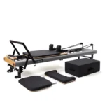Compact stackable fitness reformers with transport wheels in vertical storage layout Peak Pilates fit Reformer Grey